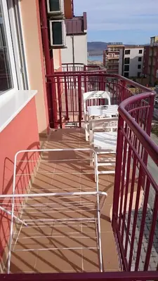 a balcony with chairs and tables on a building at Hotel Sapphire in Primorsko