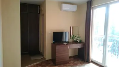 a room with a television and a dresser with a tvictericterictericter at Hotel Sapphire in Primorsko