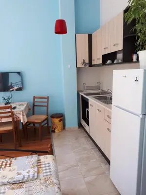 a kitchen with a white refrigerator and a table at Flowers Studio in Pomorie