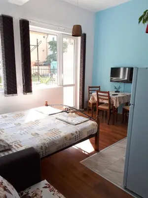 a room with a bed and a table and a window at Flowers Studio in Pomorie