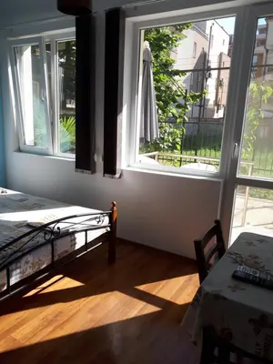 a bedroom with a bed and a window and a table at Flowers Studio in Pomorie