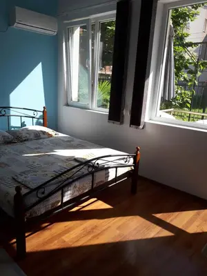 a bedroom with a bed in a room with two windows at Flowers Studio in Pomorie