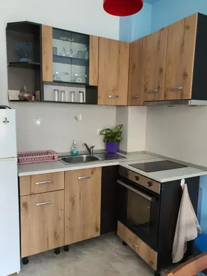 a kitchen with wooden cabinets and a sink at Flowers Studio in Pomorie