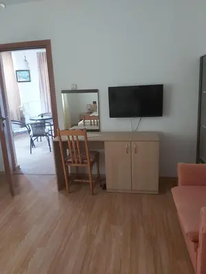 a living room with a desk with a television on a wall at Kyshta za Gosti Dari Rumi 1 in Sozopol