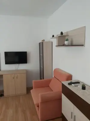 a living room with a chair and a flat screen tv at Kyshta za Gosti Dari Rumi 1 in Sozopol