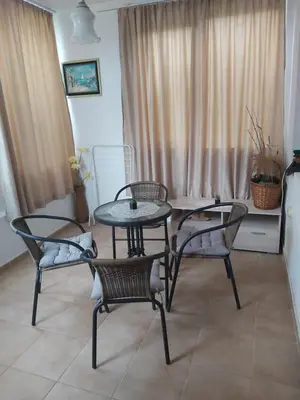 a table and chairs in a room with a window at Kyshta za Gosti Dari Rumi 1 in Sozopol