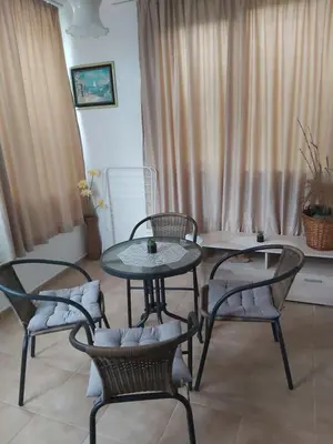 two tables and chairs in a room with curtains at Kyshta za Gosti Dari Rumi 1 in Sozopol