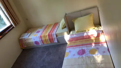 a small bedroom with two beds and a window at Sunny Paradise Family Hotel in Kiten