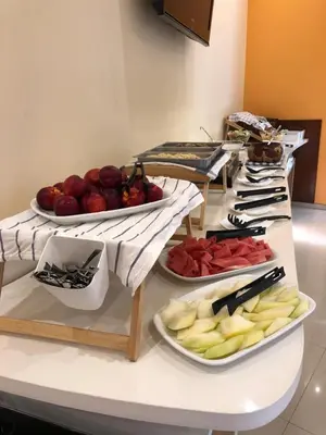 a buffet with several plates of fruit on a table at Sunny Paradise Family Hotel in Kiten