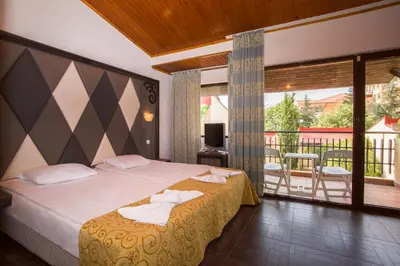 a hotel room with a bed and a balcony at Villas Elenite in Elenite