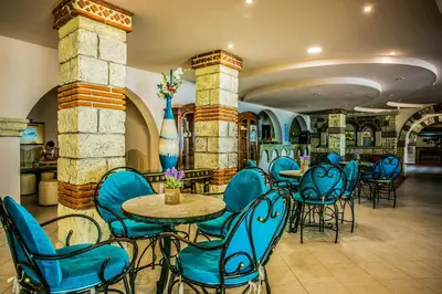 a restaurant with blue chairs and tables in a building at Villas Elenite in Elenite