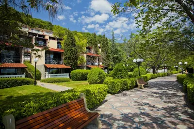 a park with a bench and bushes and buildings at Villas Elenite in Elenite