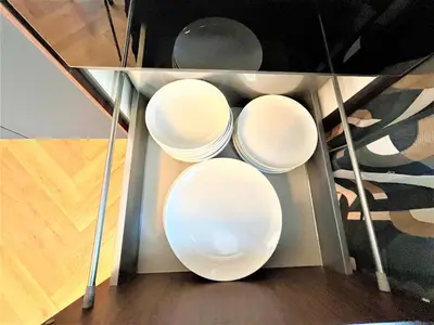three white plates sitting on a glass shelf at Bravo 5 Holiday Home in Sunny Beach