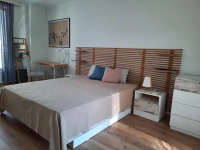 a bedroom with a large bed with a wooden headboard at Soulful Apartments - Horizon in Varna City