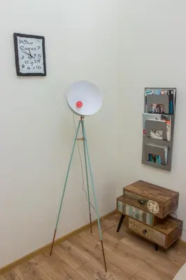 a lamp on a tripod in the corner of a room at Soulful Apartments - Horizon in Varna City