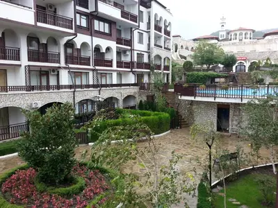 an apartment building with a garden in front of it at Arena 65m2 - 1 bedroom, 1st line to the beach in Sveti Vlas