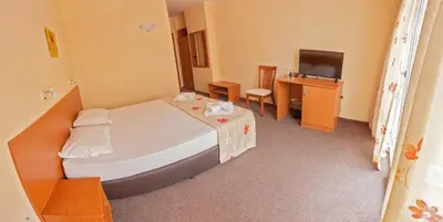 a hotel room with a bed and a television at Hotel Eva in Ravda