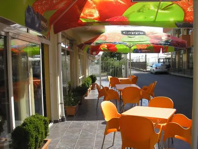 a restaurant with tables and chairs and umbrellas at Hotel Eva in Ravda
