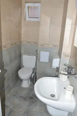 a bathroom with a toilet and a sink at Villa Valentines in Kiten