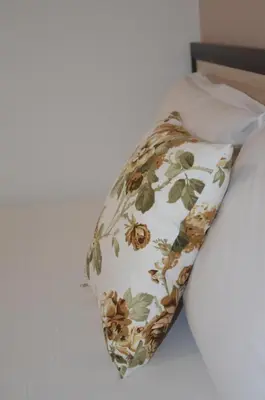 a pillow with a floral pattern on a bed at Villa Valentines in Kiten