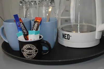 a tray with coffee cups and utensils on it at Villa Valentines in Kiten