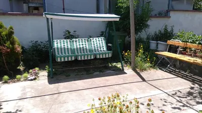 two benches sitting under a gazebo in a garden at Песента на морето in Obzor