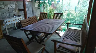 a wooden table and chairs on a patio at Песента на морето in Obzor