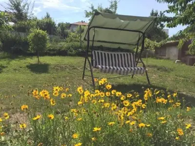 a bench in the middle of a field of flowers at Morski Rai Rooms in Byala