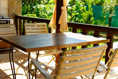 a wooden table with chairs and an umbrella on a patio at Villa Yanevi in Lozenets