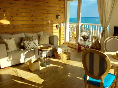 a living room with a couch and a view of the ocean at Casa de oro Alma in Sozopol