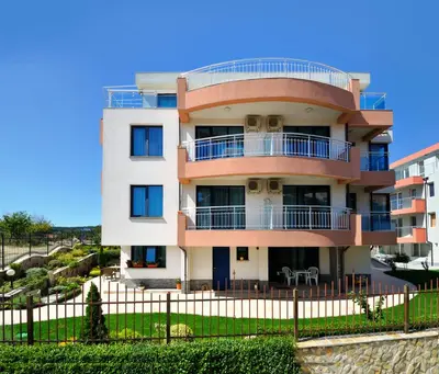 a tall building with a fence in front of it at Guest House Daris in Sozopol