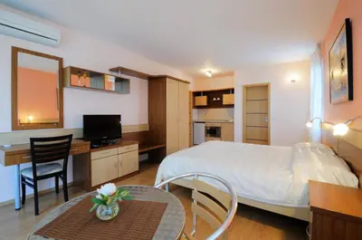 a bedroom with a bed and a desk and a table at Guest House Daris in Sozopol