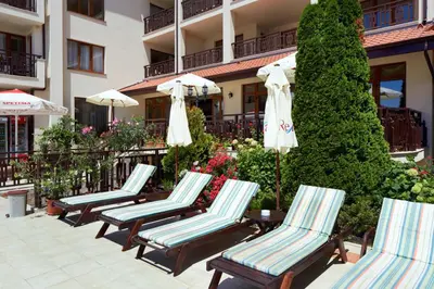 a row of chairs and umbrellas in front of a building at Relax Holiday Complex & Spa in Sunny Beach