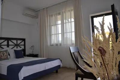 a bedroom with a bed and a chair and a window at Apartment on the Cliff Obzor in Obzor