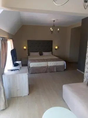 a bedroom with two beds and a television in it at Guest House Adriya in Primorsko