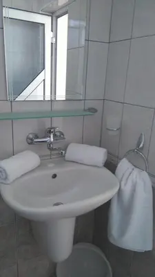 a bathroom with a white sink and a mirror at Guest House Adriya in Primorsko