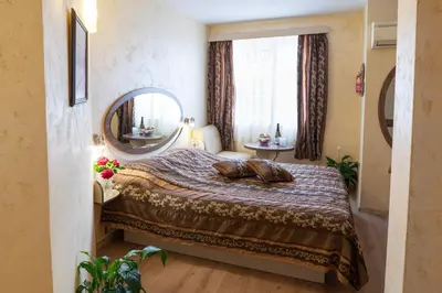 a bedroom with a bed with a large mirror at Hotel Color in Varna City