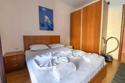 a bed with white sheets and pillows on it at Apollon Apartments in Nesebar