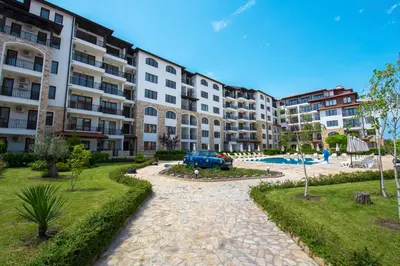 an apartment complex with a car parked in a courtyard at Apollon Apartments in Nesebar