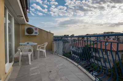 a balcony with chairs and a table on a building at Семеен хотел Бриз in Sozopol