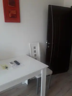 a white table and a black refrigerator in a room at Apartament Janet in Pomorie
