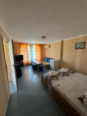 a hotel room with a bed and a living room at Hotel Laguna - Guest House in Primorsko