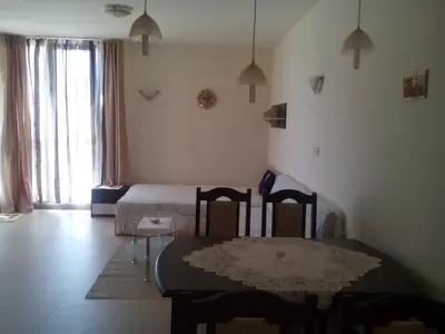 a living room with a table and a bed at Byala Relax Apartments in Byala