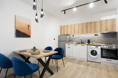 a kitchen with a table and blue chairs at Семеен хотел Golden Place in Sozopol