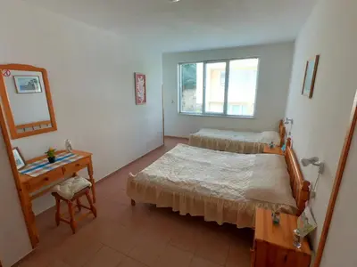 a bedroom with a bed and a table and a mirror at Apartment in St. Vlas with terrace in Sveti Vlas