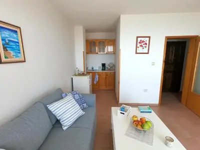 a living room with a blue couch and a table at Apartment in St. Vlas with terrace in Sveti Vlas
