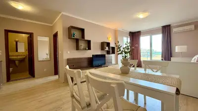 a dining room and living room with a table and chairs at Bratanov Asteria Family in Sunny Beach