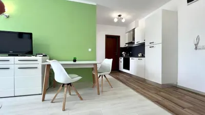 a kitchen with a table and two white chairs at Bratanov Asteria Family in Sunny Beach