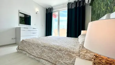 a bedroom with a bed and a tv and a window at Bratanov Asteria Family in Sunny Beach