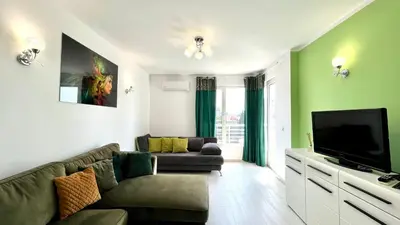 a living room with a couch and a flat screen tv at Bratanov Asteria Family in Sunny Beach